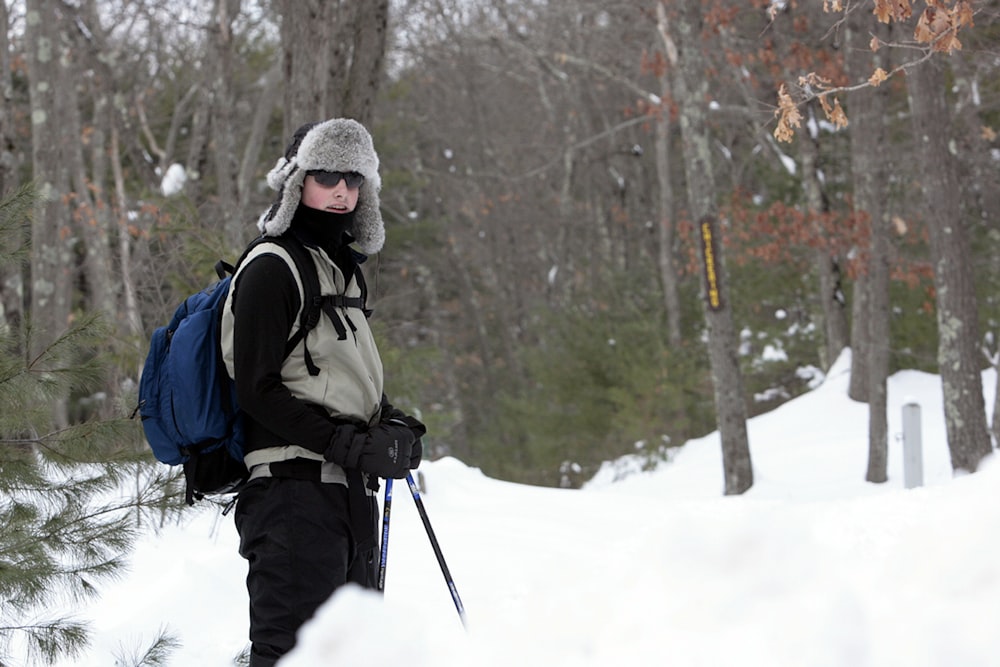a person with a backpack and skis in the snow