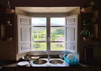 a kitchen with a double sink and open window