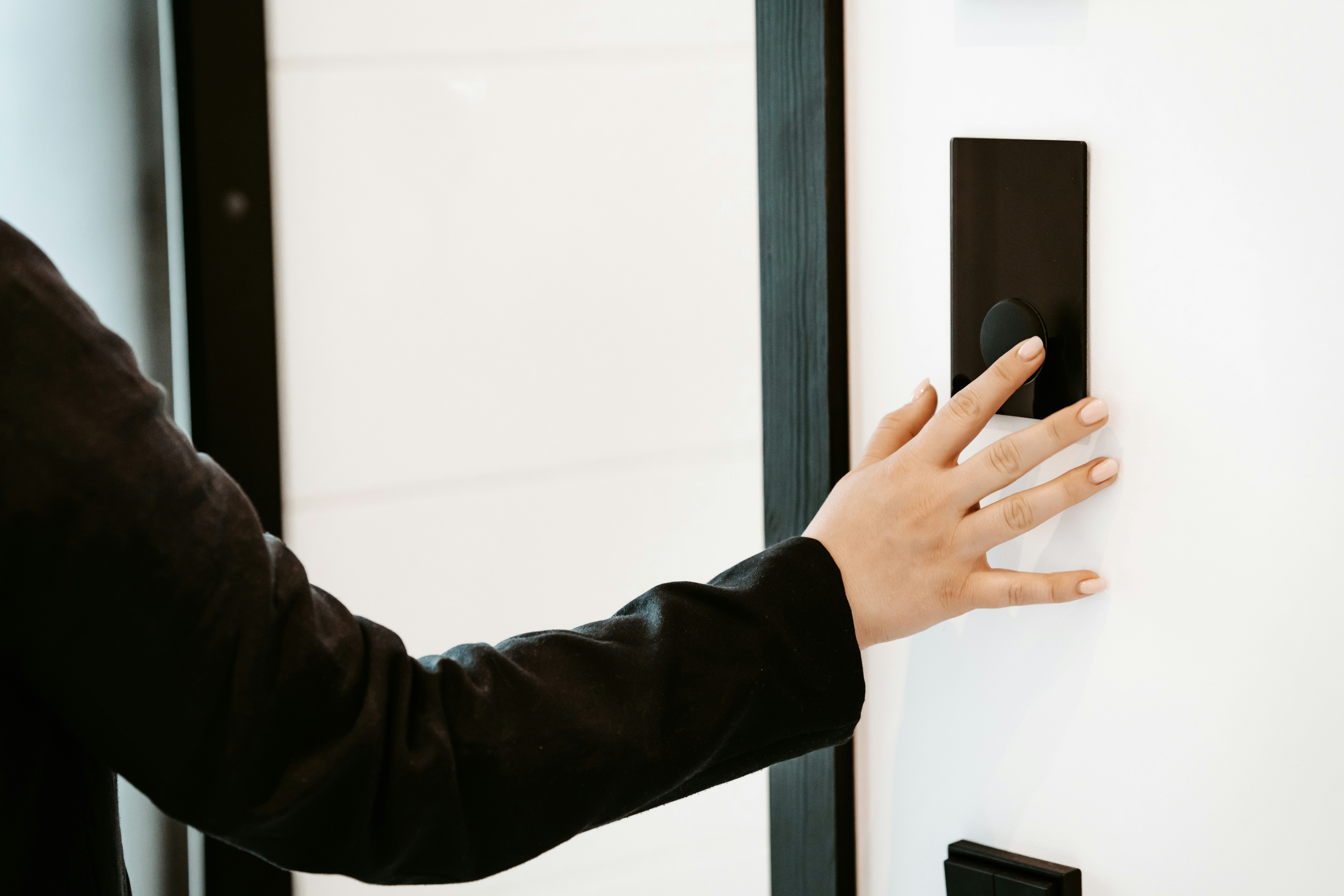 person pointing to the "Learn" button on a garage door opener motor unit - garage door opener keypad