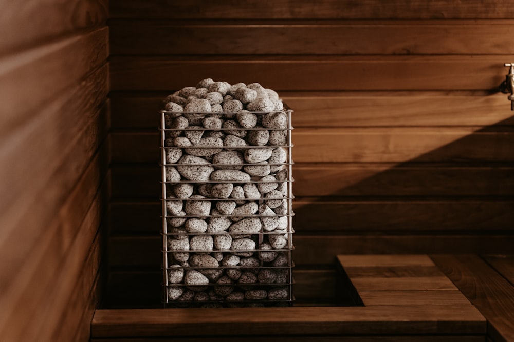 a basket filled with rocks sitting on top of a wooden table