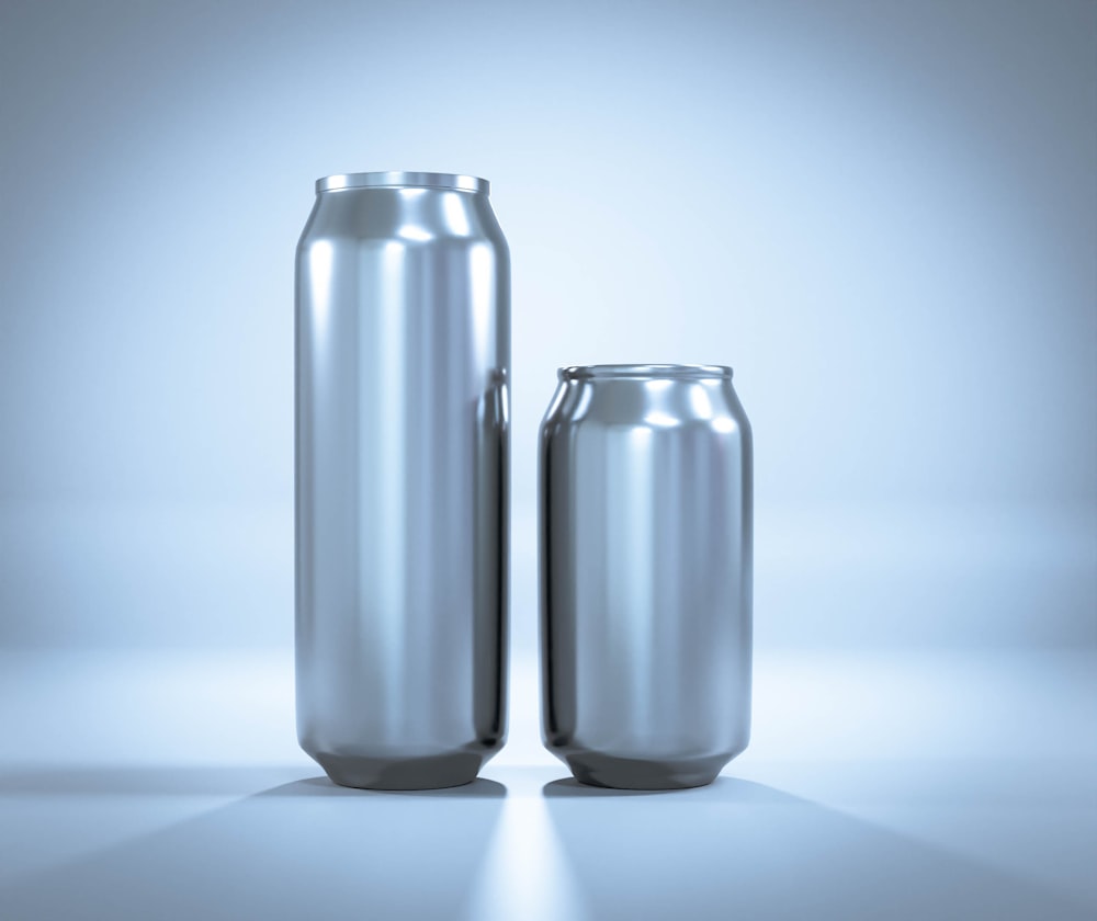 two shiny metal cans sitting next to each other