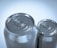 Two aluminum beverage cans are positioned closely together. The focus is on the top lids with pull tabs, showcasing a metallic and reflective surface. Lighting highlights the shiny texture and smooth curves of the cans.