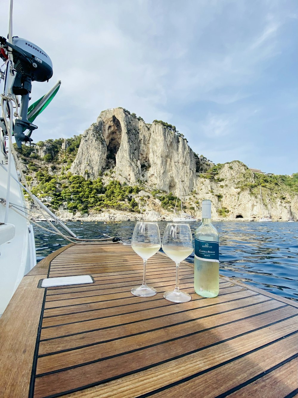 two wine glasses sitting on a wooden dock