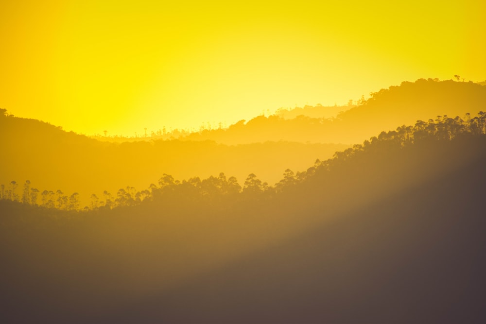 the sun is setting over a mountain range