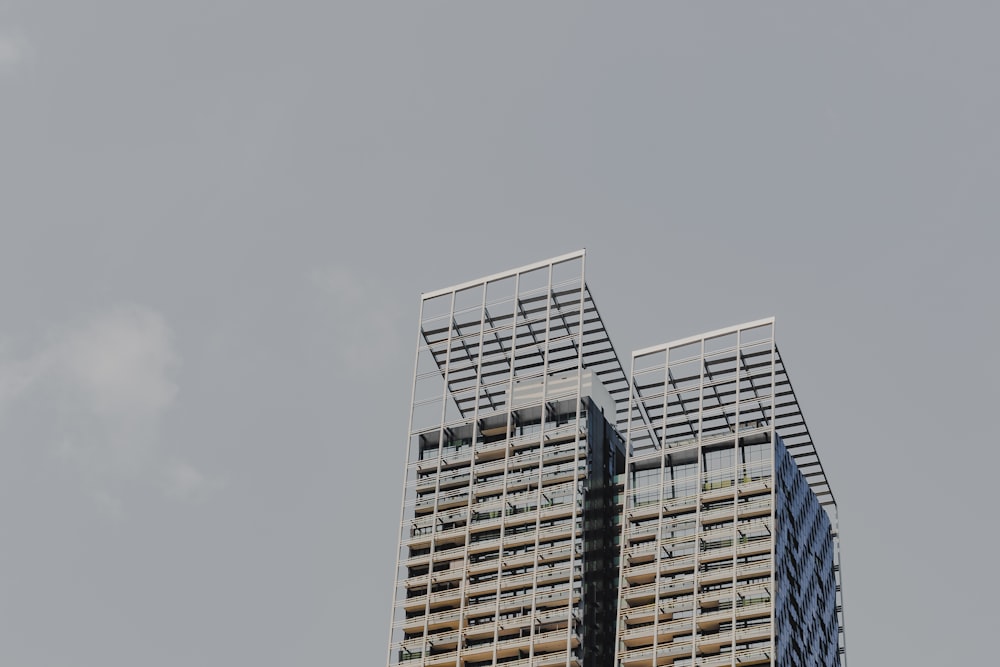 Zwei hohe Gebäude mit Balkonen vor grauem Himmel