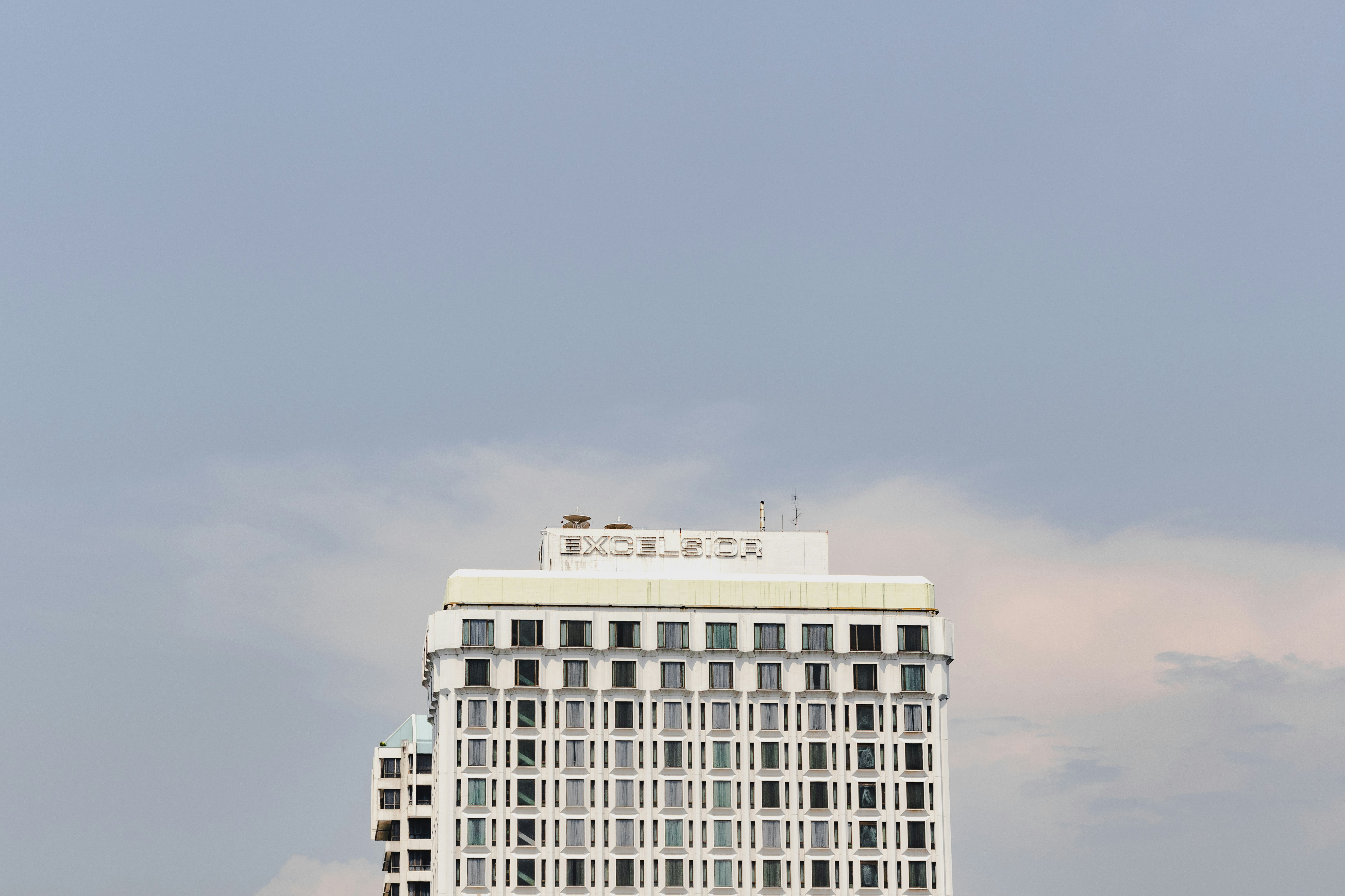 a tall white building with a sky in the background, 