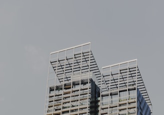 a plane flying in the sky over a tall building