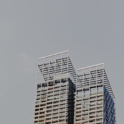 a plane flying in the sky over a tall building