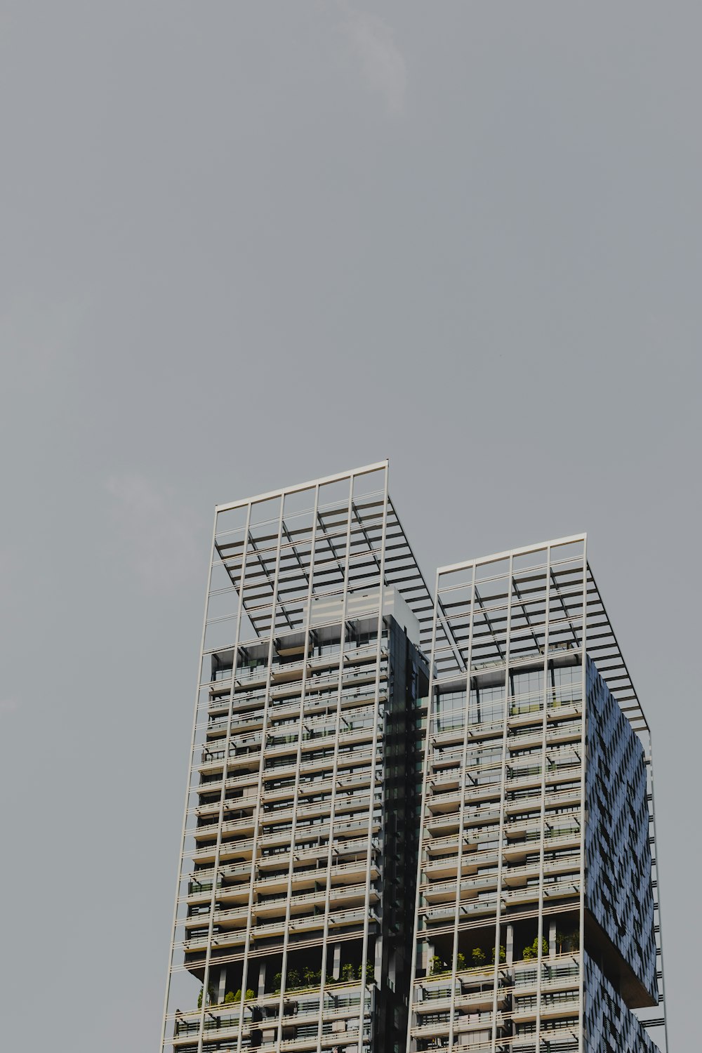 a plane flying in the sky over a tall building