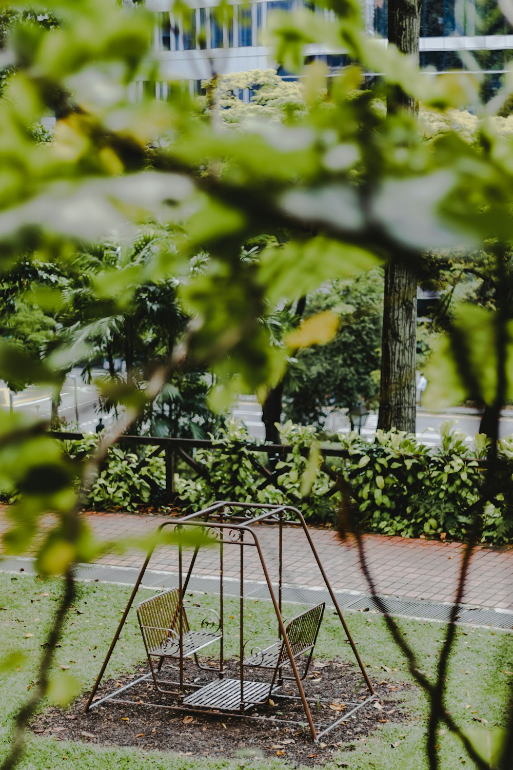 a swing set in a park surrounded by greenery