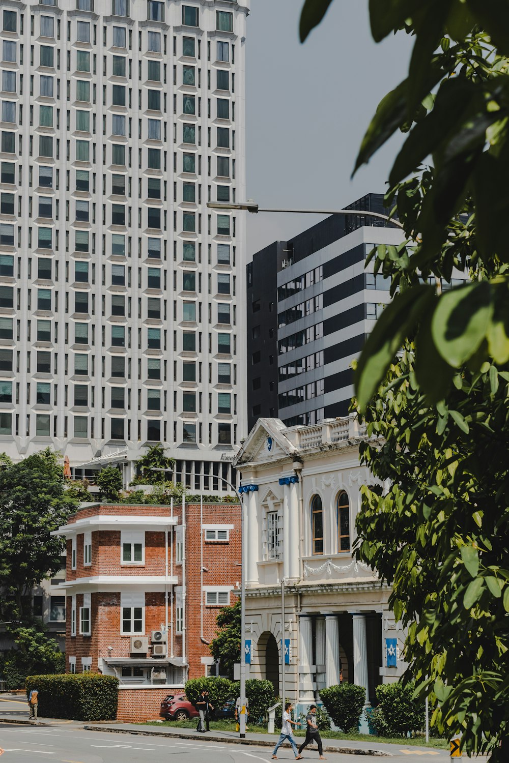 a group of people walking down a street next to tall buildings