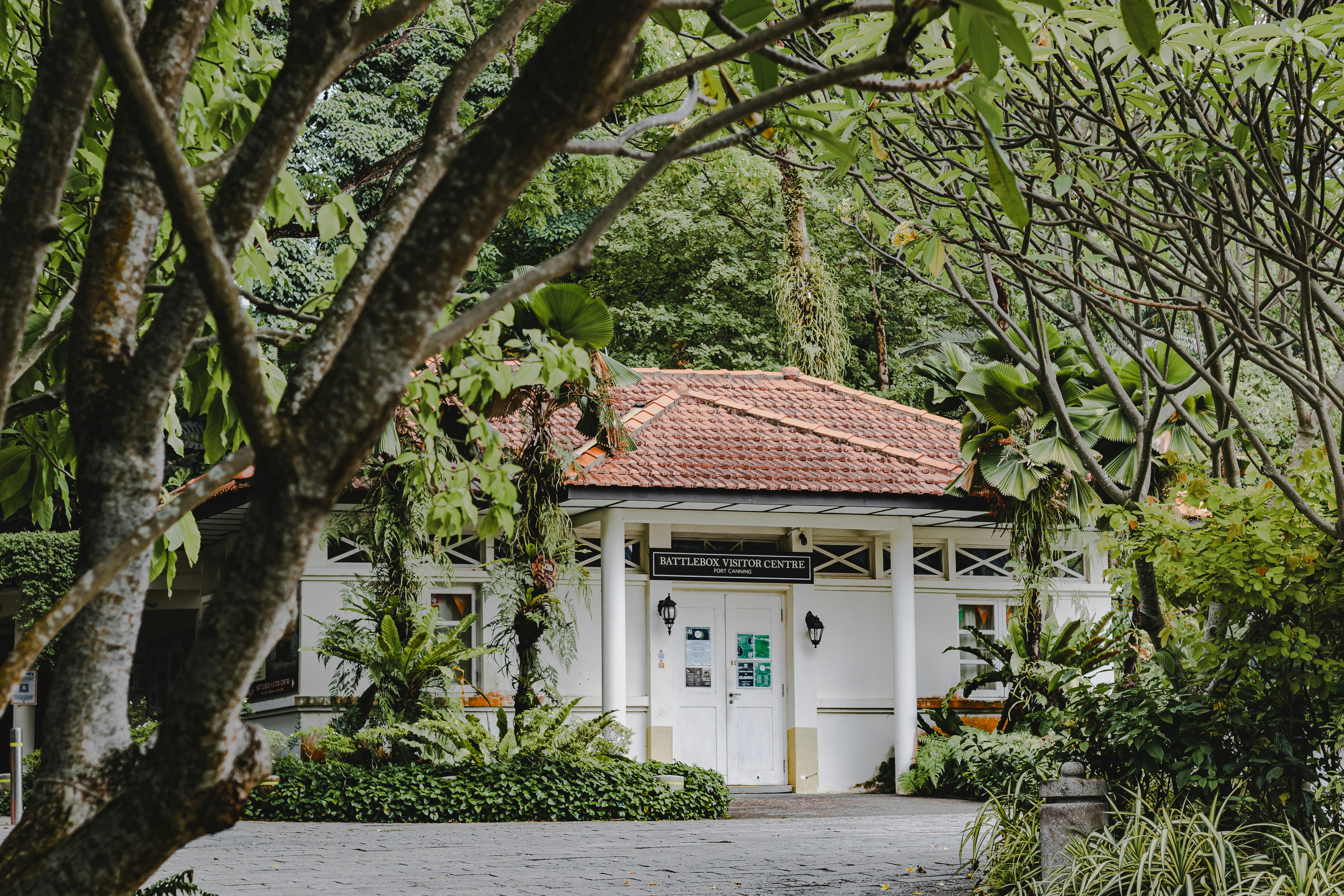 a white building with a red roof surrounded by trees