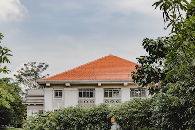 a white house with a red roof surrounded by trees