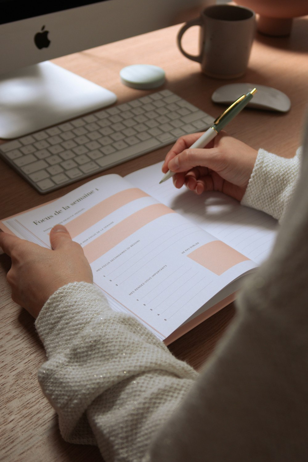 a person sitting at a desk writing on a piece of paper