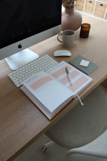 a desk with a computer, keyboard and a cup of coffee