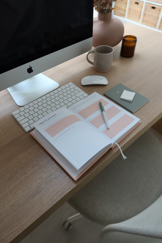 a desk with a computer, keyboard and a cup of coffee