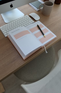 an open notebook sitting on top of a wooden desk