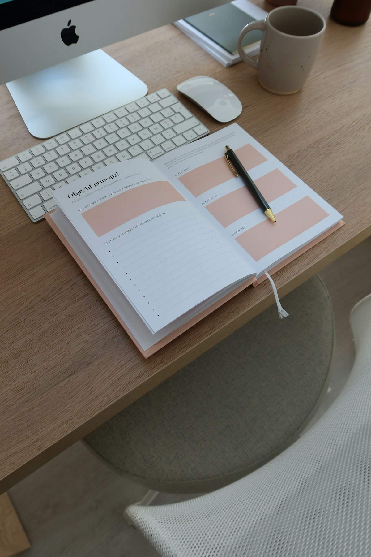 Minimalist white desk with planner, pen and calculator
