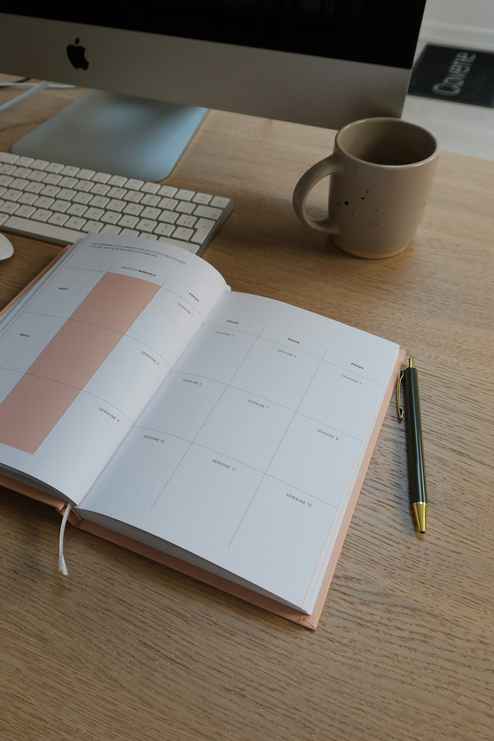 an open book sitting on top of a desk next to a keyboard