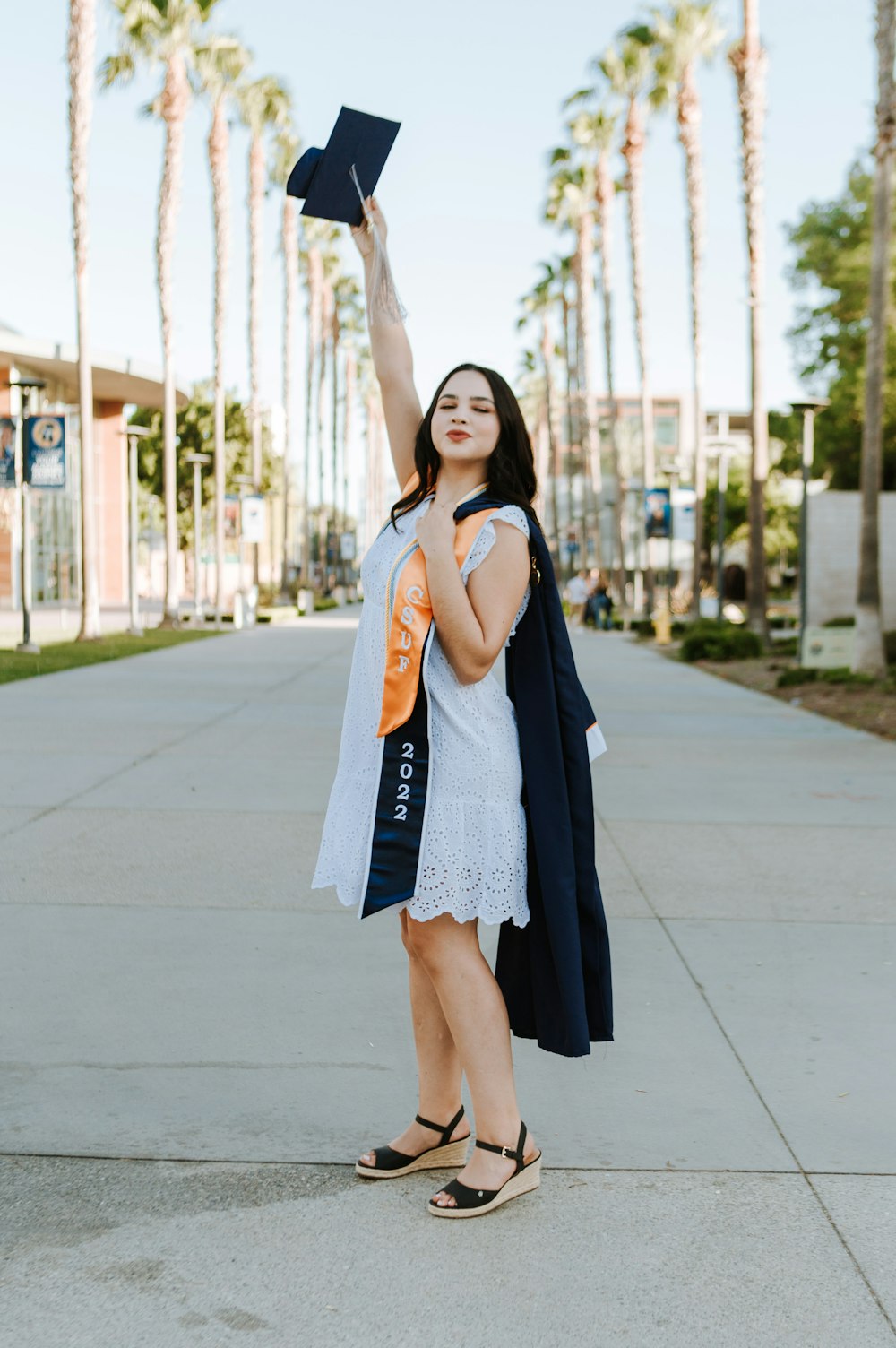 a woman in a white dress is holding a book