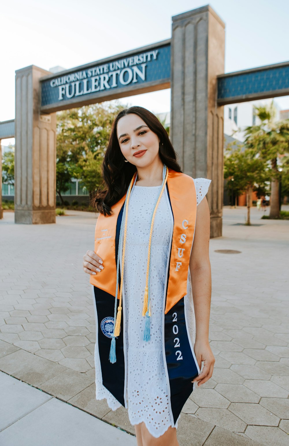 a woman in a white dress and orange vest