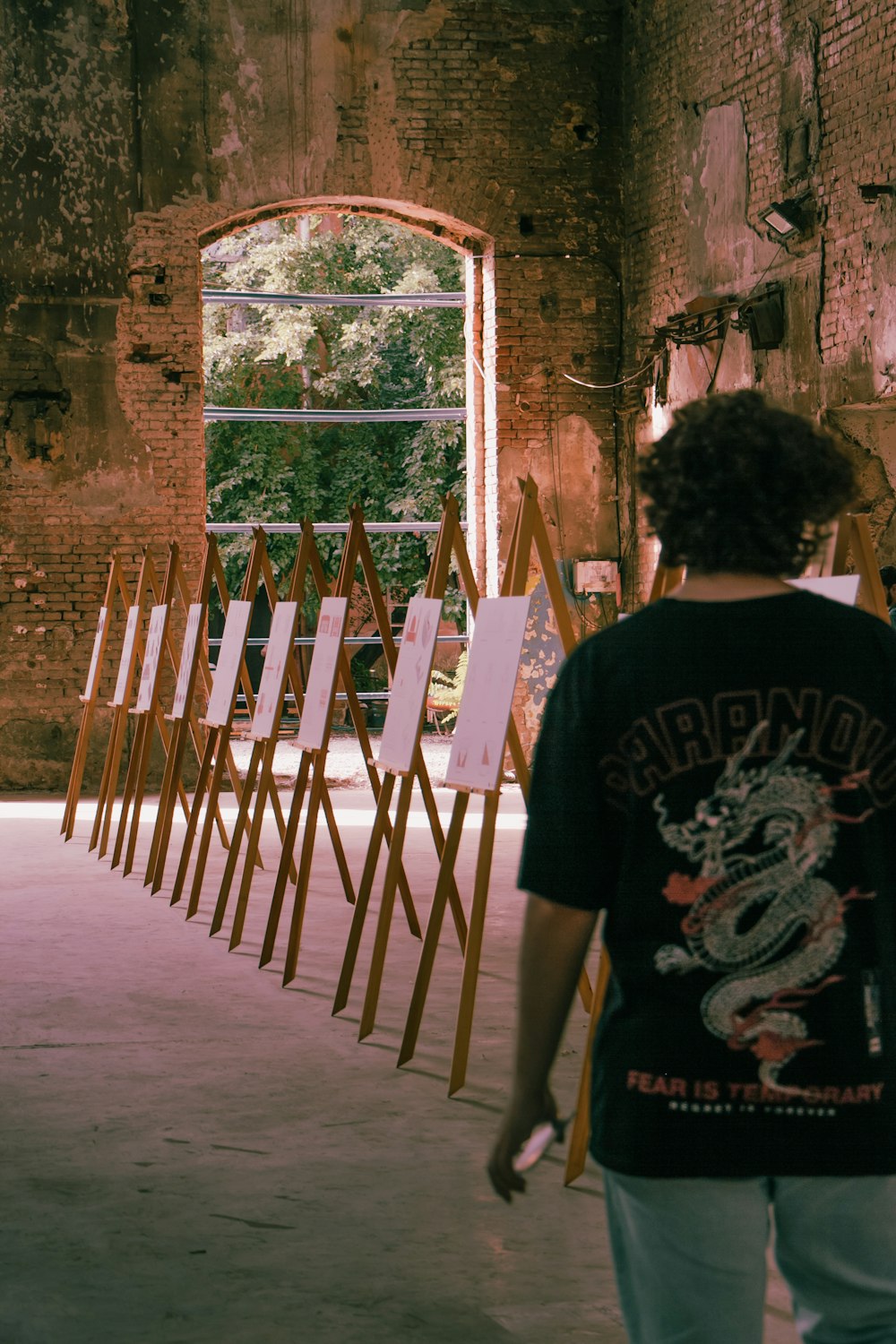 a person standing in front of a row of easels