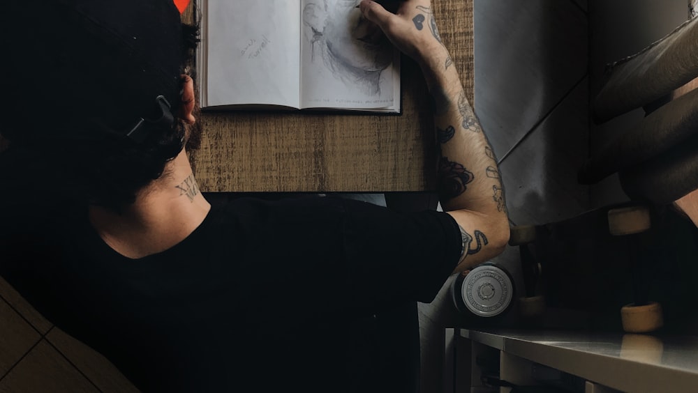 a man sitting at a table writing on a piece of paper