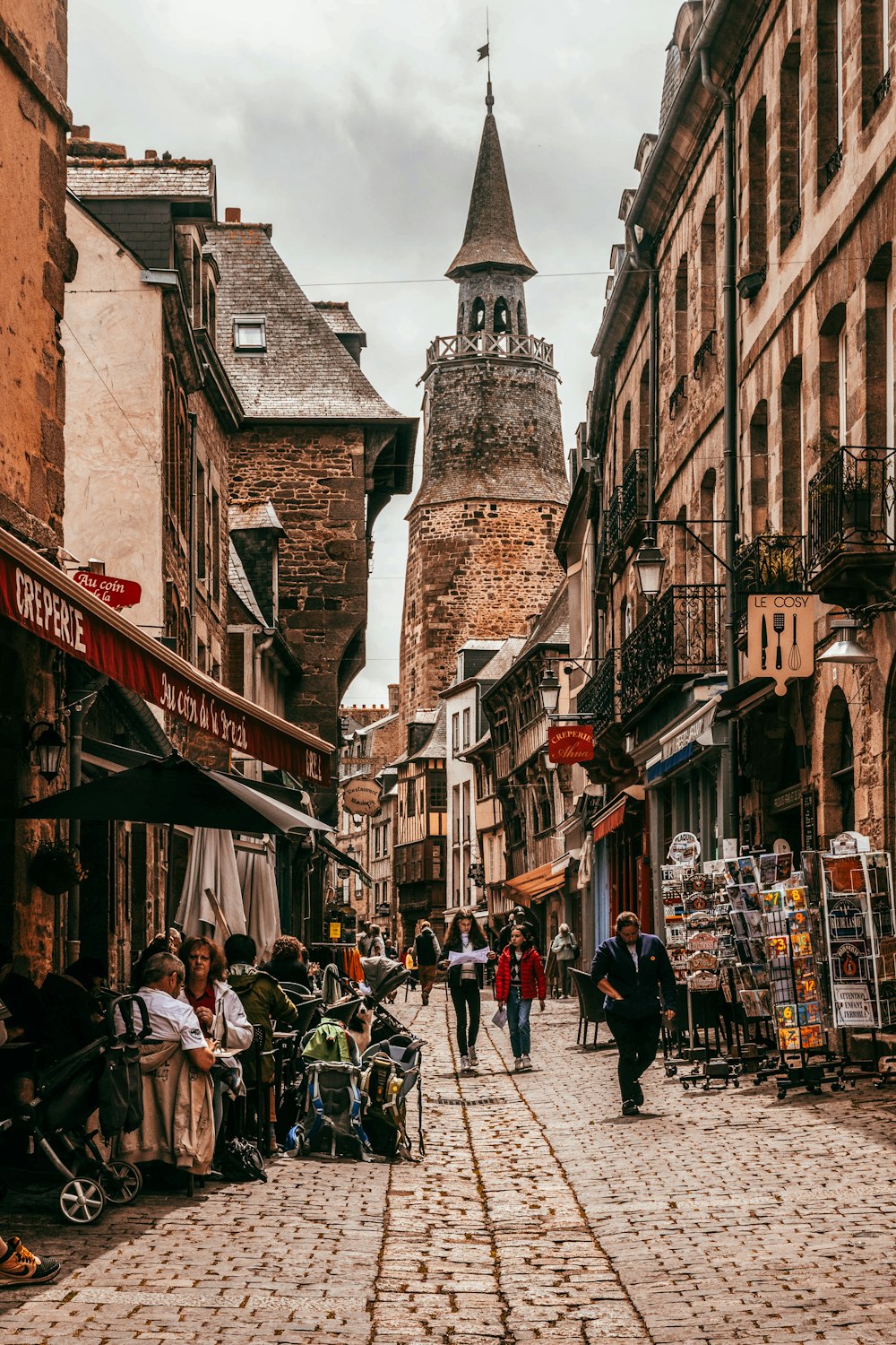 a group of people walking down a cobblestone street