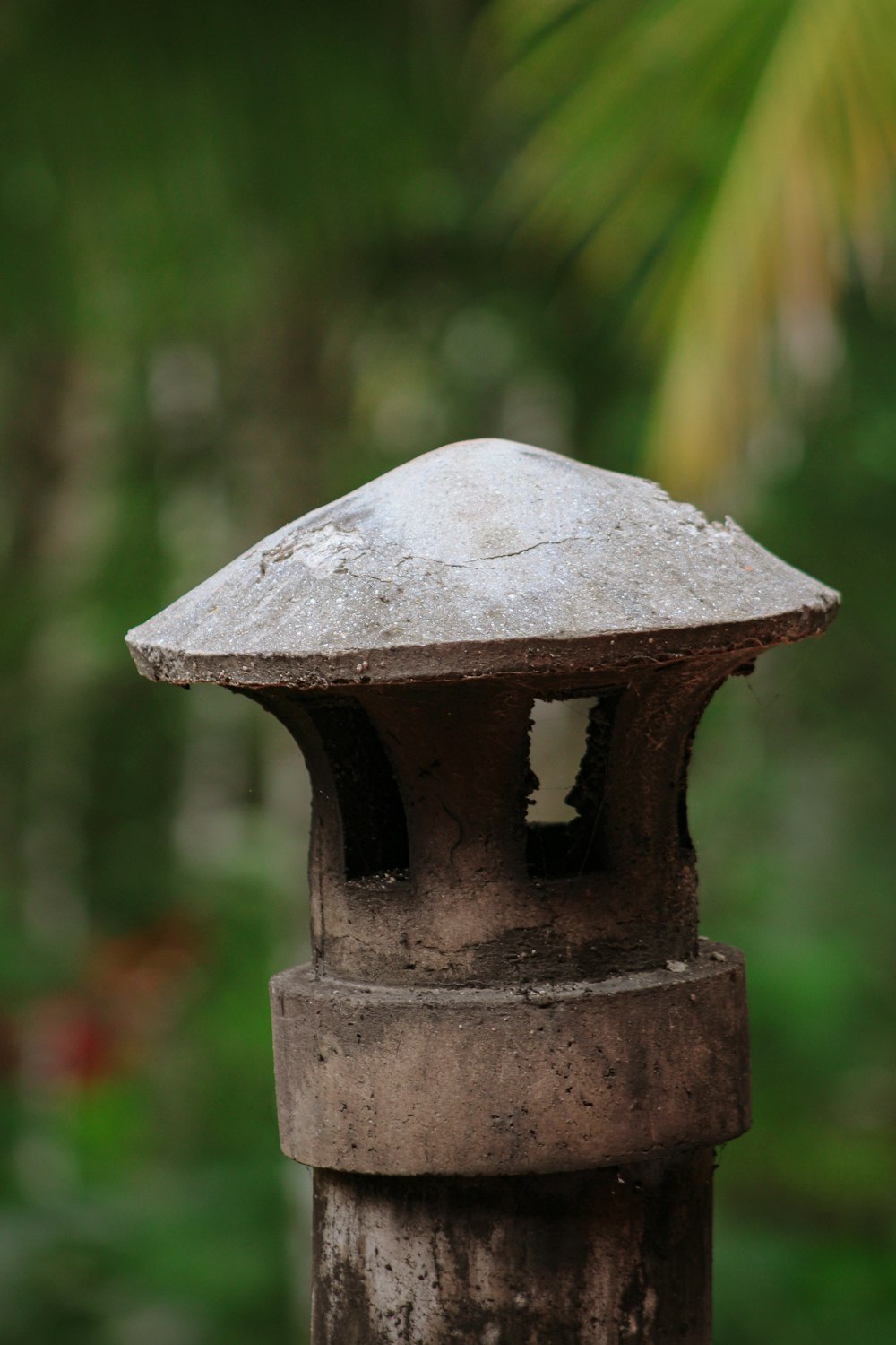 a close up of a metal object with trees in the background