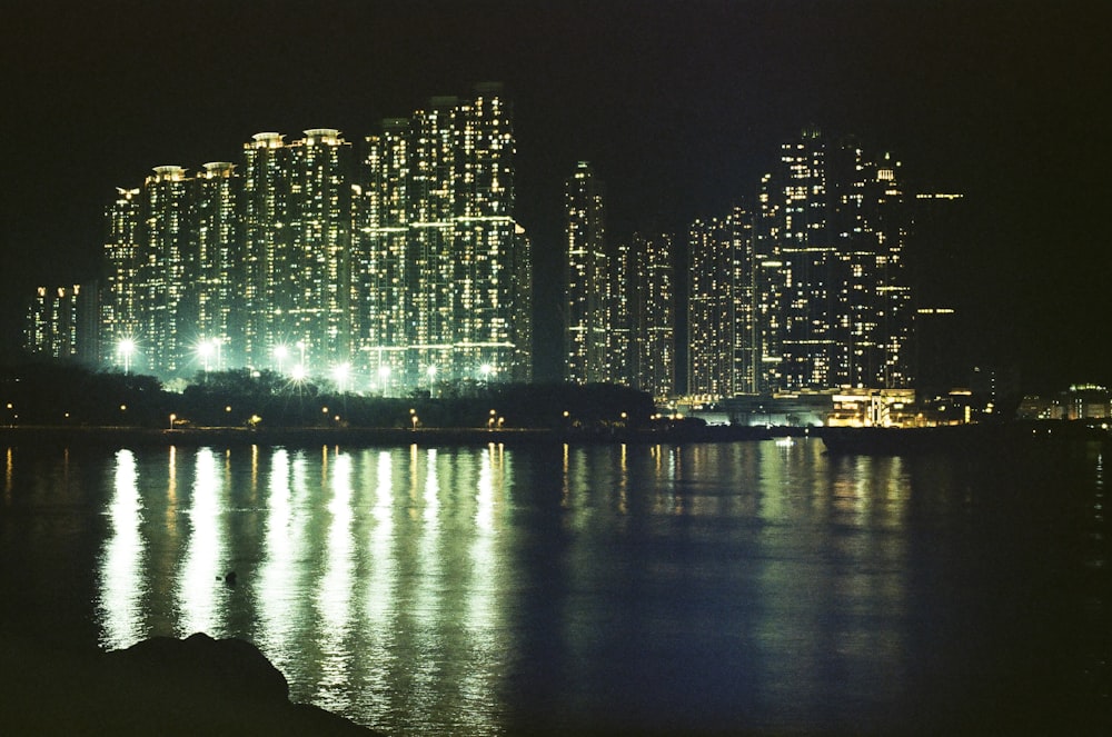 a city at night with lights reflecting in the water