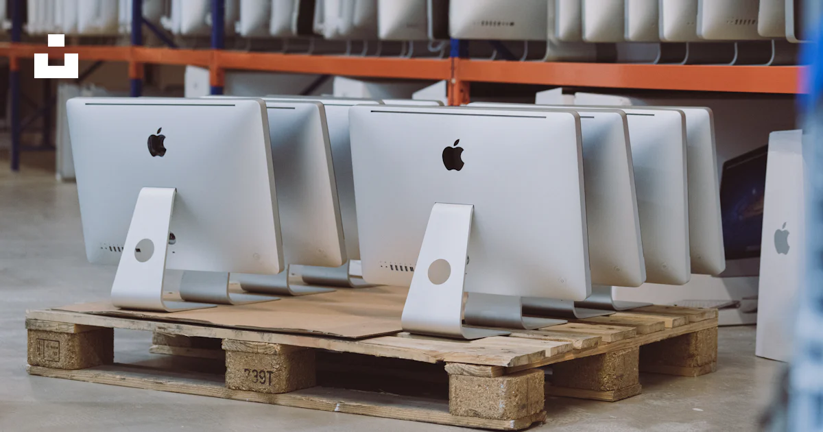 A row of apple computers sitting on pallets in a store photo – Free ...