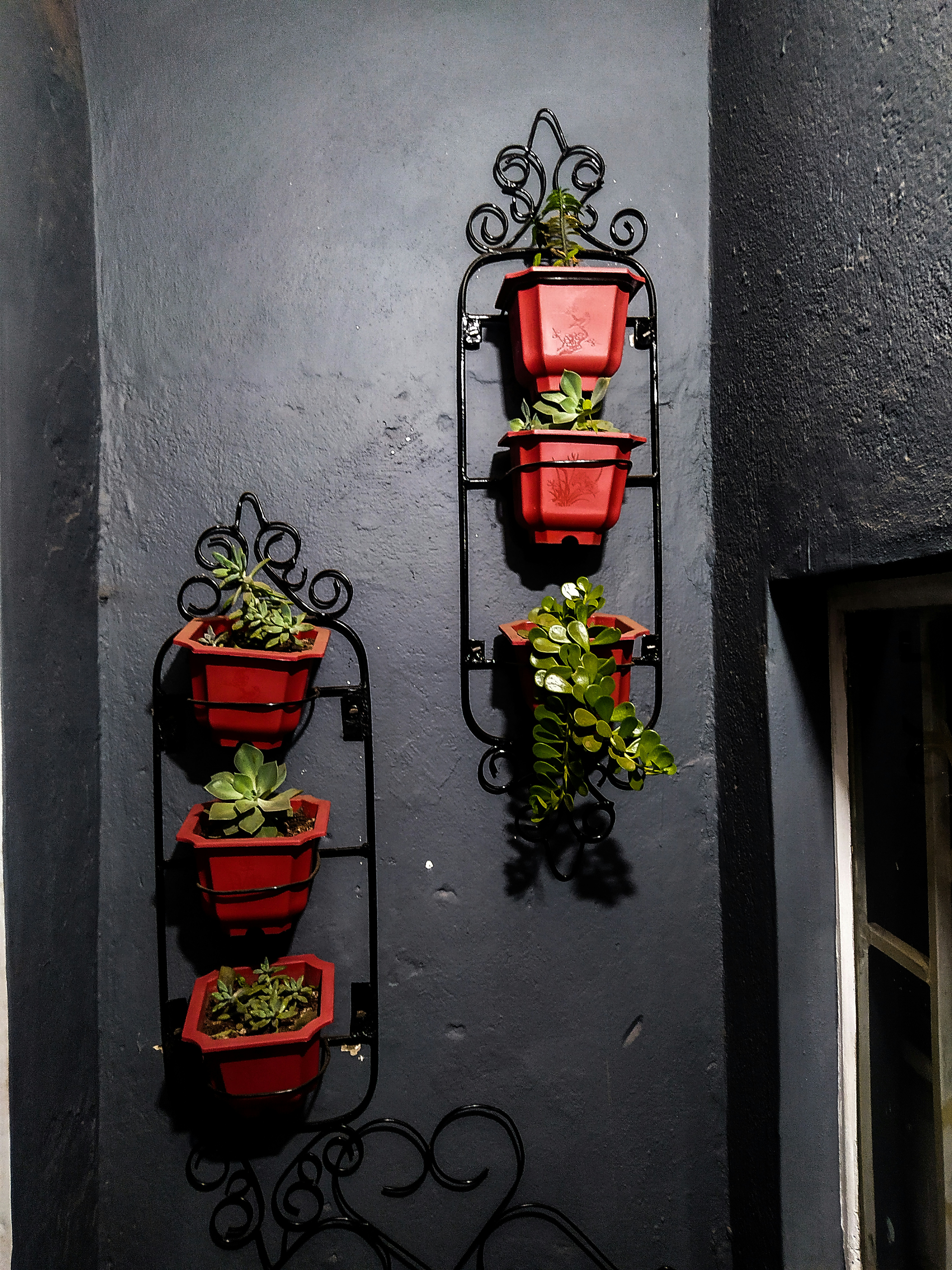 a couple of red planters mounted to the side of a wall