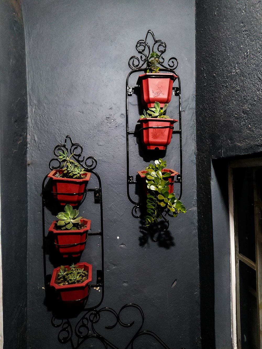 a couple of red planters mounted to the side of a wall