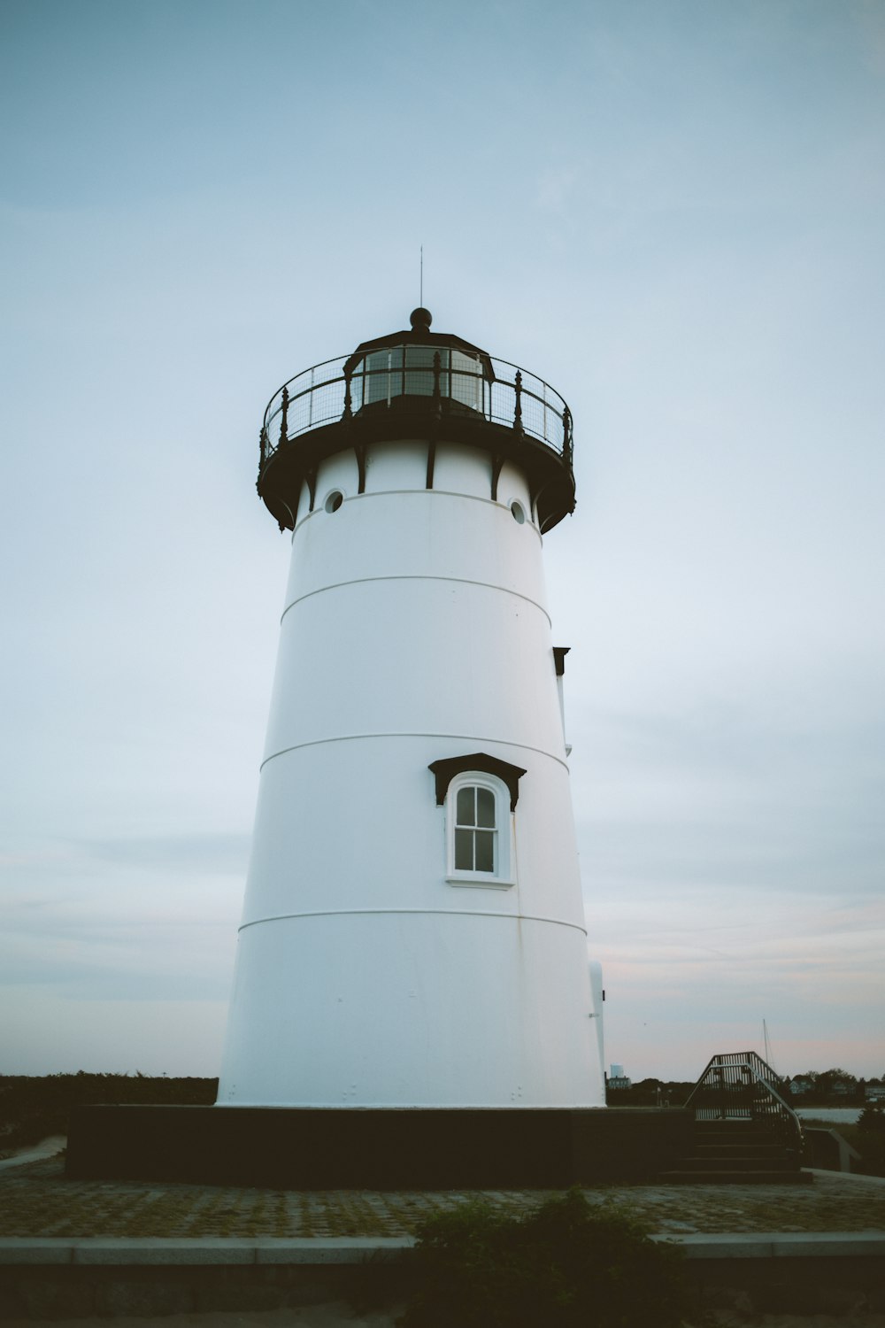 a large white lighthouse sitting on top of a sandy beach