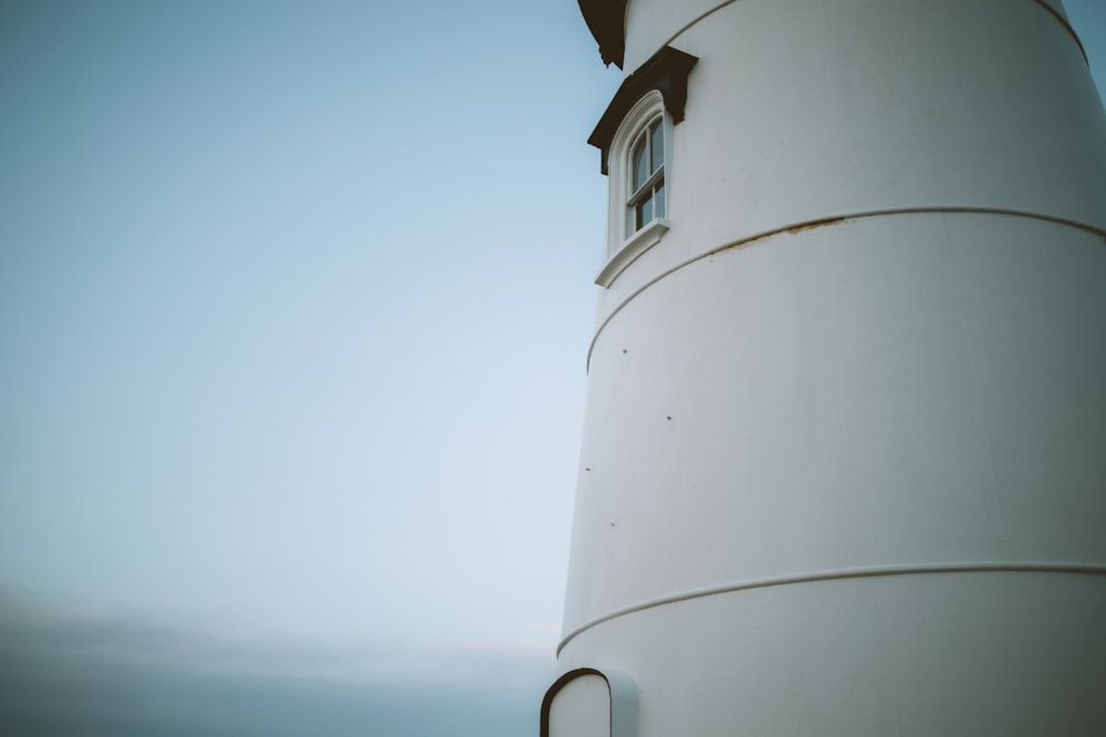 a large white tower with a clock on it's side