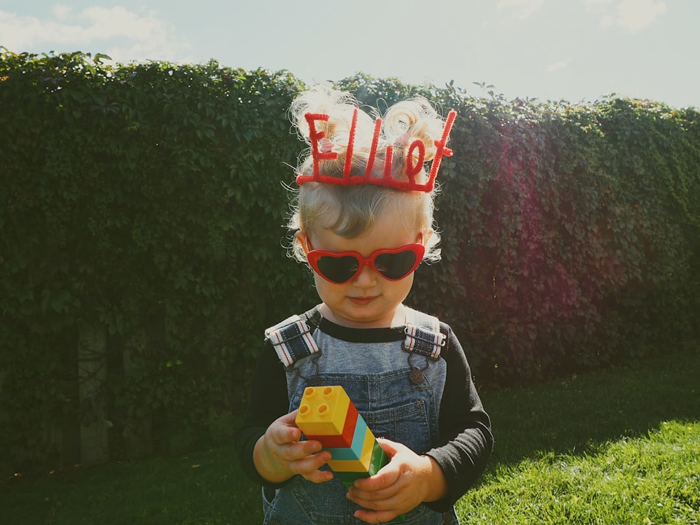 a little boy wearing a silly hat and sunglasses