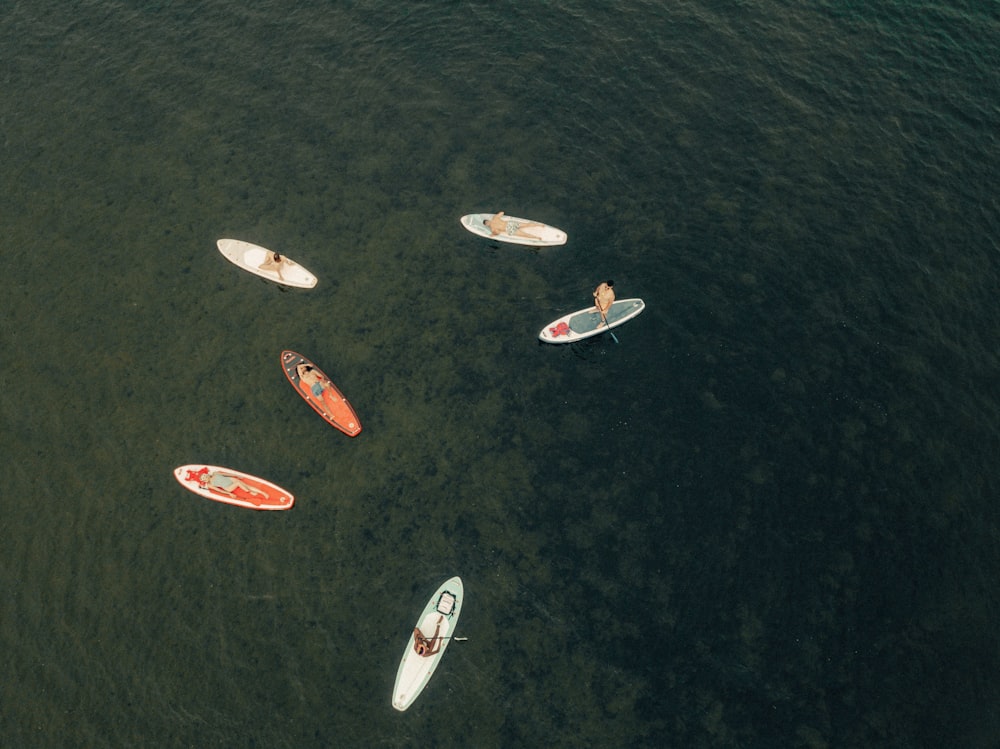 a group of people riding surfboards on top of a body of water