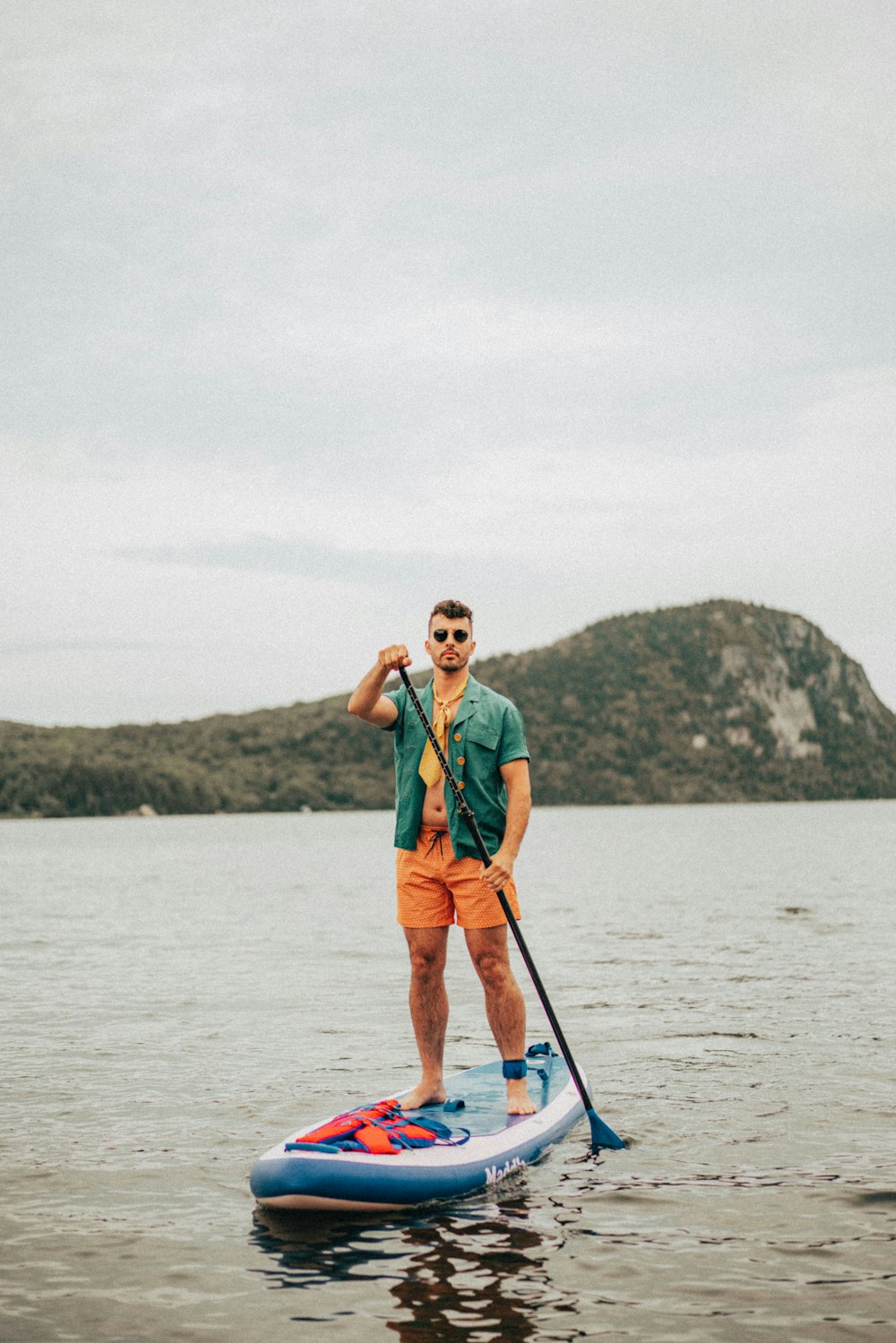 a man standing on a paddle board in the water