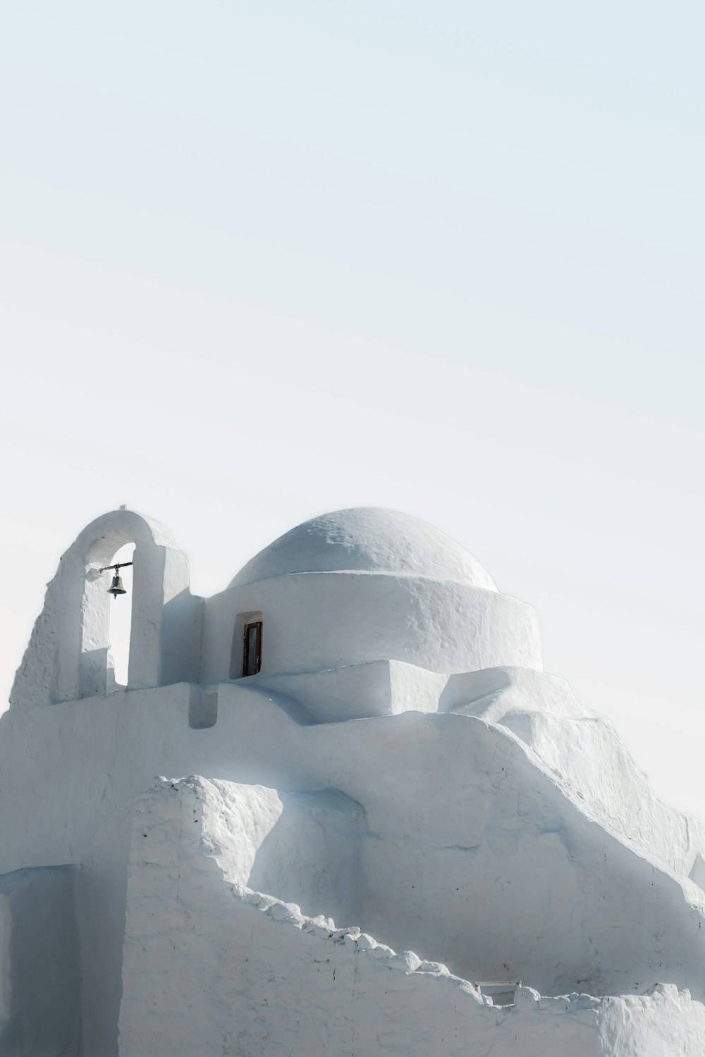 a white building with a bell on top of it