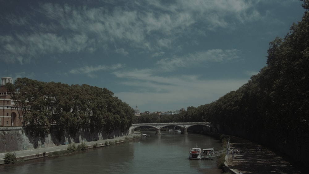 a boat traveling down a river next to a bridge