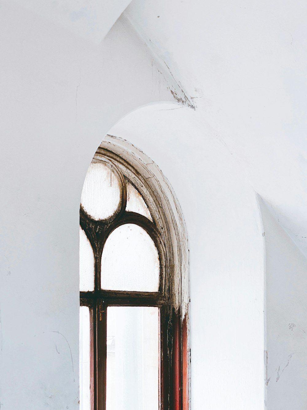 a window in a white wall with red trim