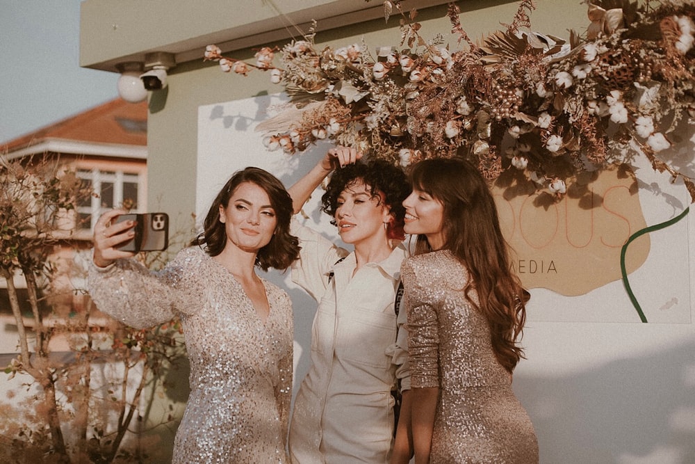 three women taking a selfie in front of a building