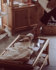 Close-up of hands selecting buttons and ribbons in a warm, inviting retail setting.