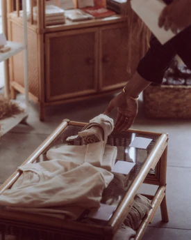 Close-up of hands inspecting a gently used children's clothing item in a cozy boutique setting.