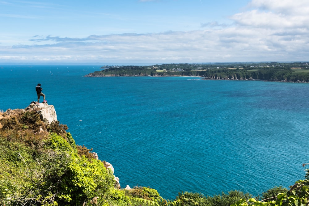 a person standing on a cliff overlooking the ocean