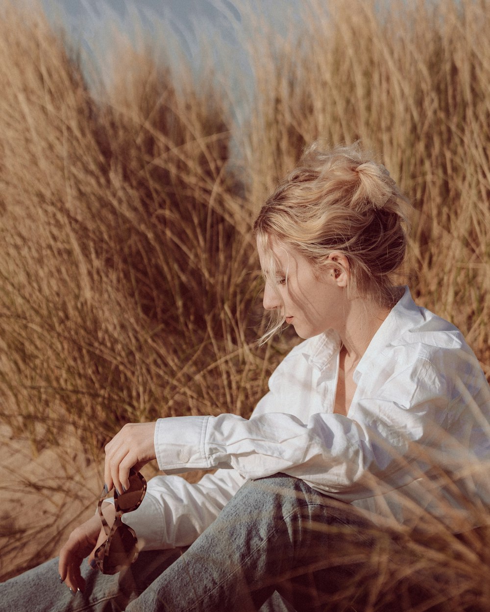 Eine Frau sitzt auf einem Feld mit hohem Gras