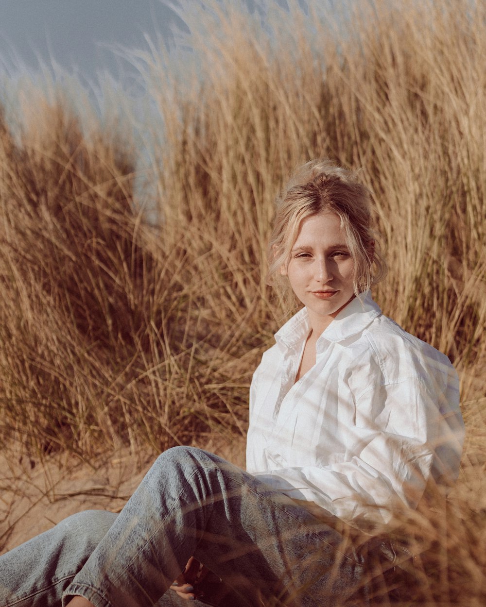 a woman sitting in a field of tall grass