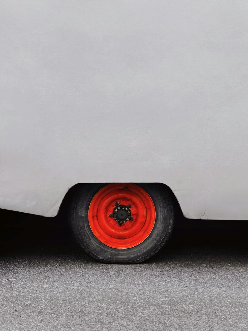 a close up of a red tire on a white car