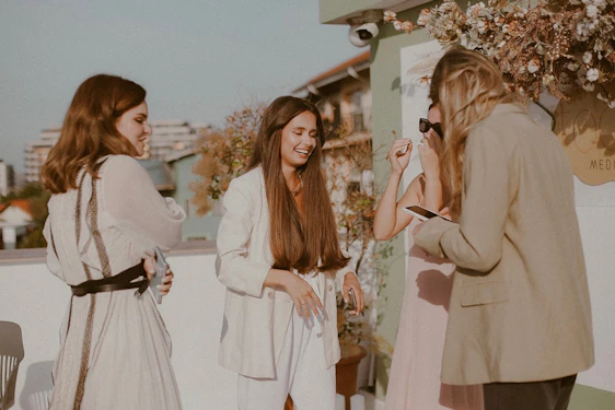 A group of professional women networking in a modern office with a view of the Riviera Maya coastline.