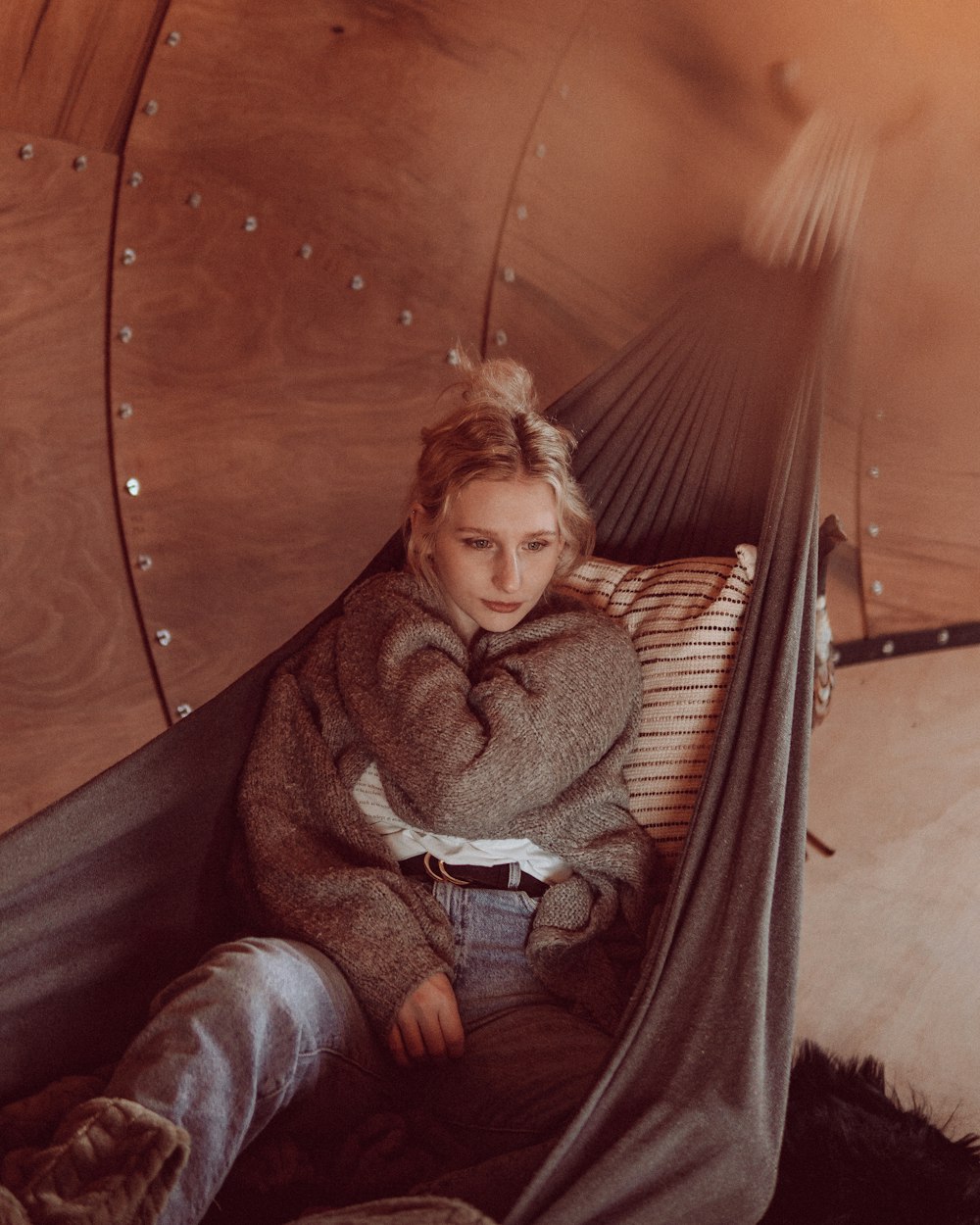 a woman sitting in a hammock in a room